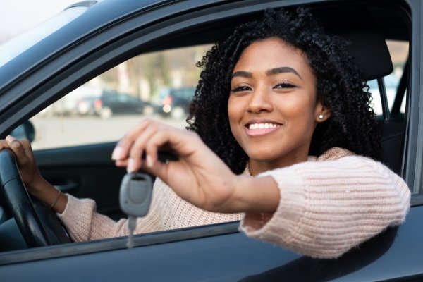 root insurance car insurance cost price how much woman in the car behind the wheel smiling car key in hand